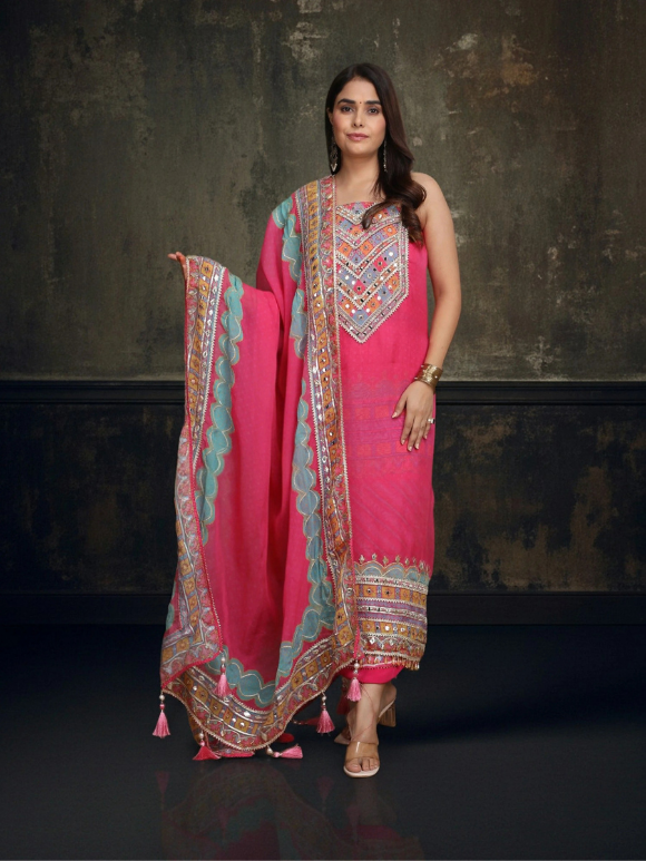 Vibrant pink ethnic ensemble with intricate mirror work and scalloped printed dupatta 