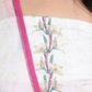 Close-up of blend of soft ombre shades, delicate embroidery, and vibrant floral prints